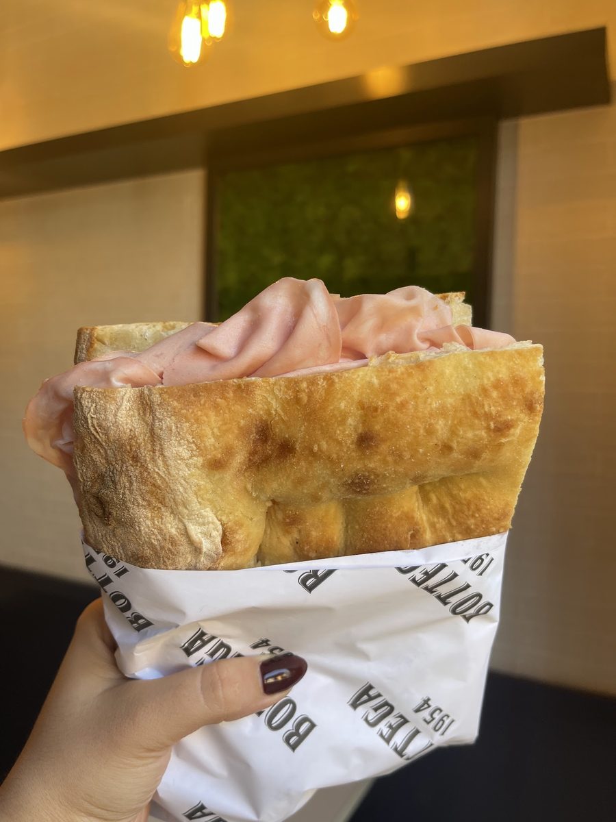 Focaccia alla pala farcita con mortadella, servita nella carta di Bottega 1954