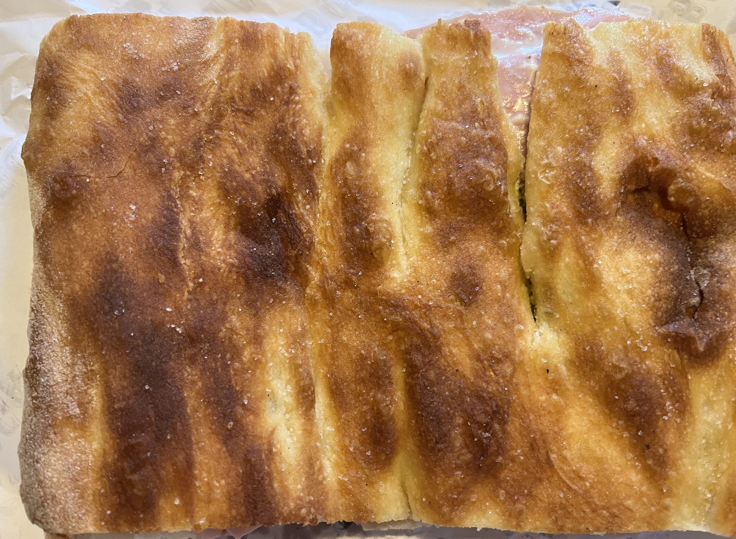 Primo piano della focaccia alla pala aperta a metà, con la crosta dorata e gli alveoli